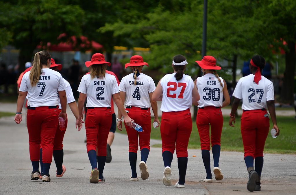Members of the SEMO Smashers 04 softball team walk towards the field